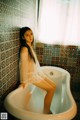 A woman sitting in a bathtub in a bathroom.