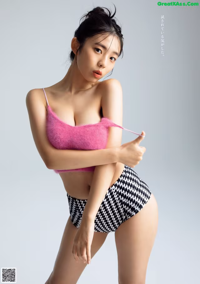A woman in a pink top and black and white houndstooth shorts.