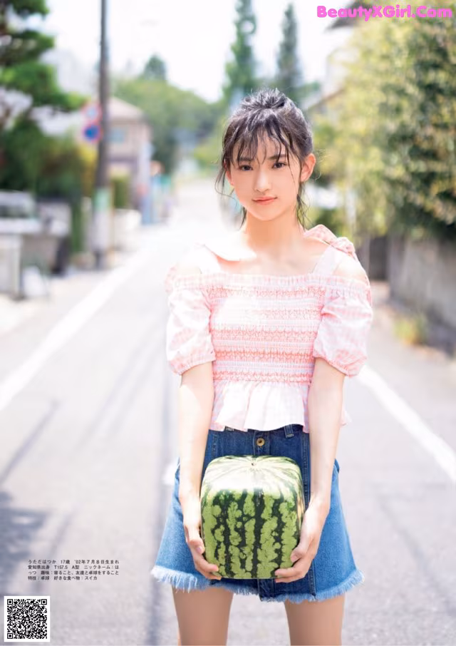 A woman holding a watermelon in her hands.