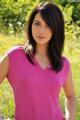 A woman in a pink shirt posing for a picture.