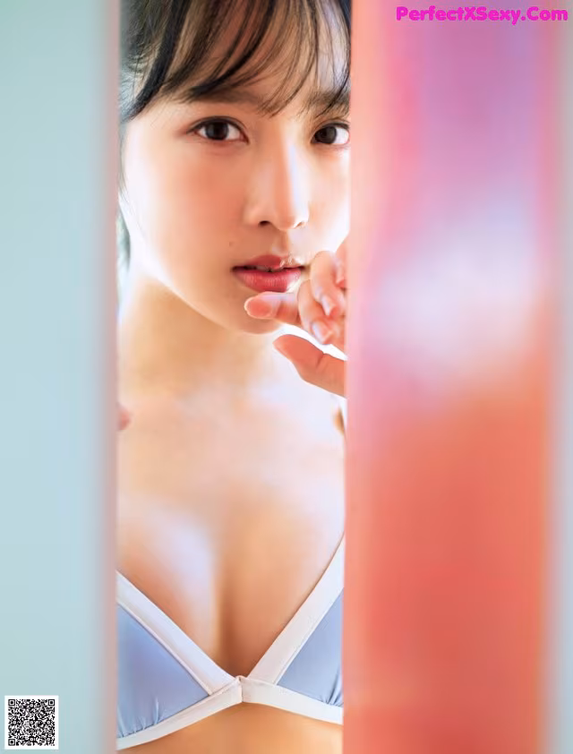 A woman in a blue bra is looking at the camera.