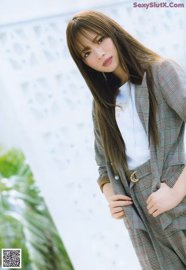 A woman in a plaid suit posing for a picture.