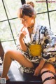 A woman in a kimono sitting on a window sill.