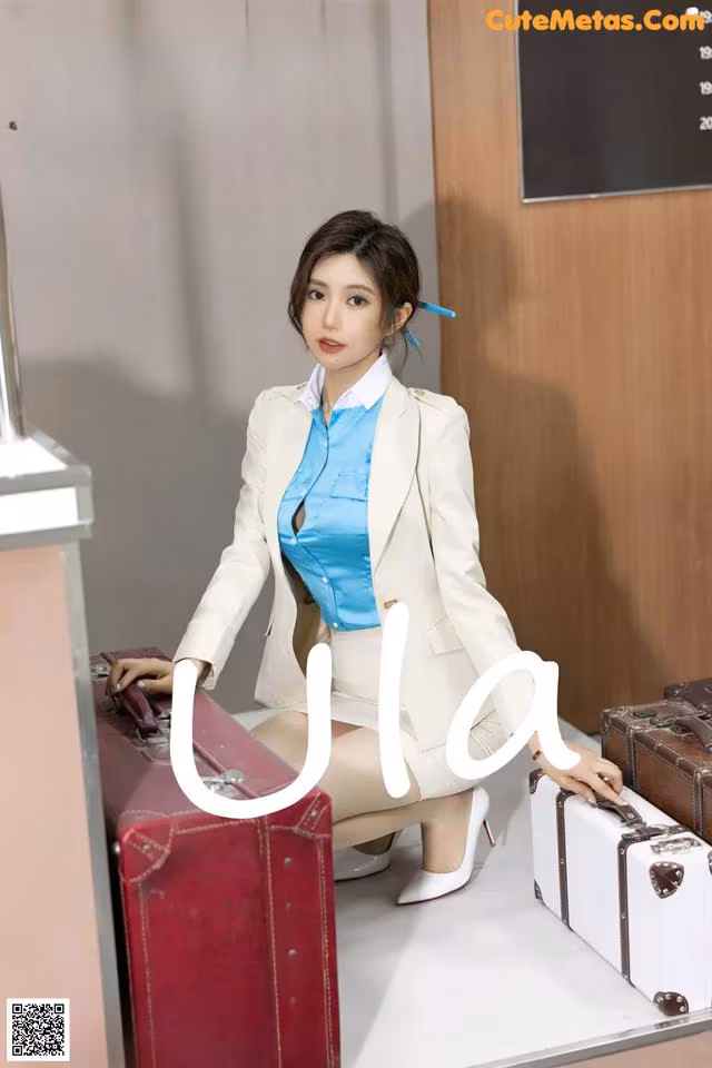 A woman sitting on top of a table next to suitcases.